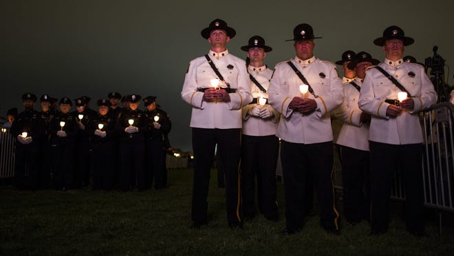 Law enforcement officers hold candles during the National Law Enforcement Officers Memorial Fund 30th annual Candlelight Vigil.