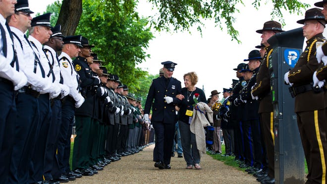 Family members of police officers killed in the line of duty pass an honor guard as they arrive for the National Law Enforcement Officers Memorial Fund 30th annual Candlelight Vigil.