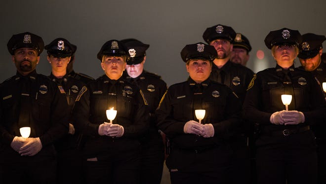 Law enforcement officers hold candles during the National Law Enforcement Officers Memorial Fund 30th annual Candlelight Vigil.