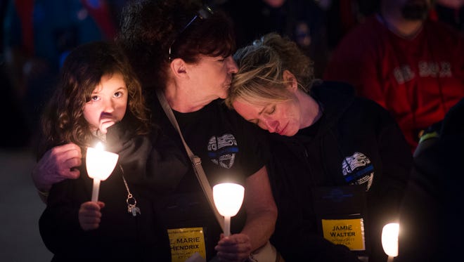 Jamie Walter, right, is comforted by her mother Marie Hendrix, center, as her daughter Addison Walter, looks on, during the National Law Enforcement Officers Memorial Fund 30th annual Candlelight Vigil. Walter's husband Virginia State Police Special Agent Michael Walter was killed in the line of duty on May 27, 2017.