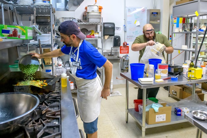Patrick Couri, left, works on a veggie lentil pie recipe while his co-chef Alexander Bartoloni makes some fresh hummus for a weekend dining event at Sous Chef, 1311 SW Adams St. in Peoria's Warehouse District.