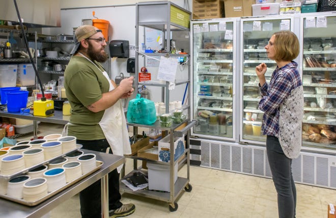 Alexander Bartoloni, left, of Sous Chef chats with Rebecca Gnagey, owner of Morton-based Pumpkin Village Farms, who supplies homegrown micro-greens for the Warehouse District grocery store and kitchen in Peoria.