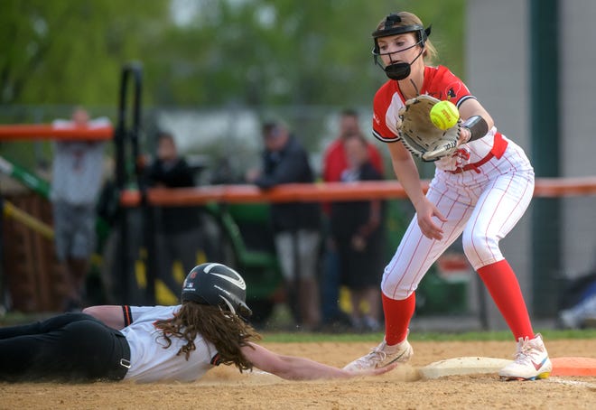 Washington's Devon Mlekush dives safely back to first base as Metamora's Bri Bessert catches the pickoff attempt during their Mid-Illini Conference softball game Thursday April 25, 2024 at Jan Smith Field in Washington. The Redbirds defeated the Panthers 11-2.