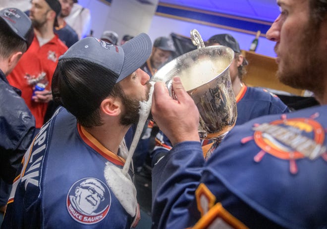 Peoria's Joe Drapluk, left, takes a swig of beer from the President's Cup in the Rivermen locker room after their team's 5-1 victory over the Huntsville Havoc in the deciding game of the SPHL President's Cup finals Sunday, April 28, 2024 at the Peoria Civic Center.
