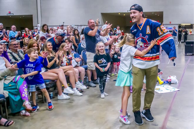 A young fan embraces Zach Wilkie of the Peoria Rivermen after his speech at a public celebration for the team's SPHL President's Cup hockey championship Friday, May 3, 2024 at the Peoria Civic Center.