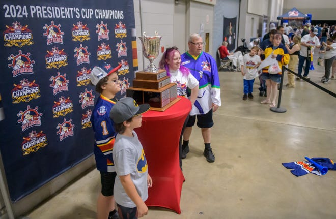 Fans get their photo taken with the SPHL President's Cup during a public celebration for the champion Peoria Rivermen on Friday, May 3, 2024 at the Peoria Civic Center.